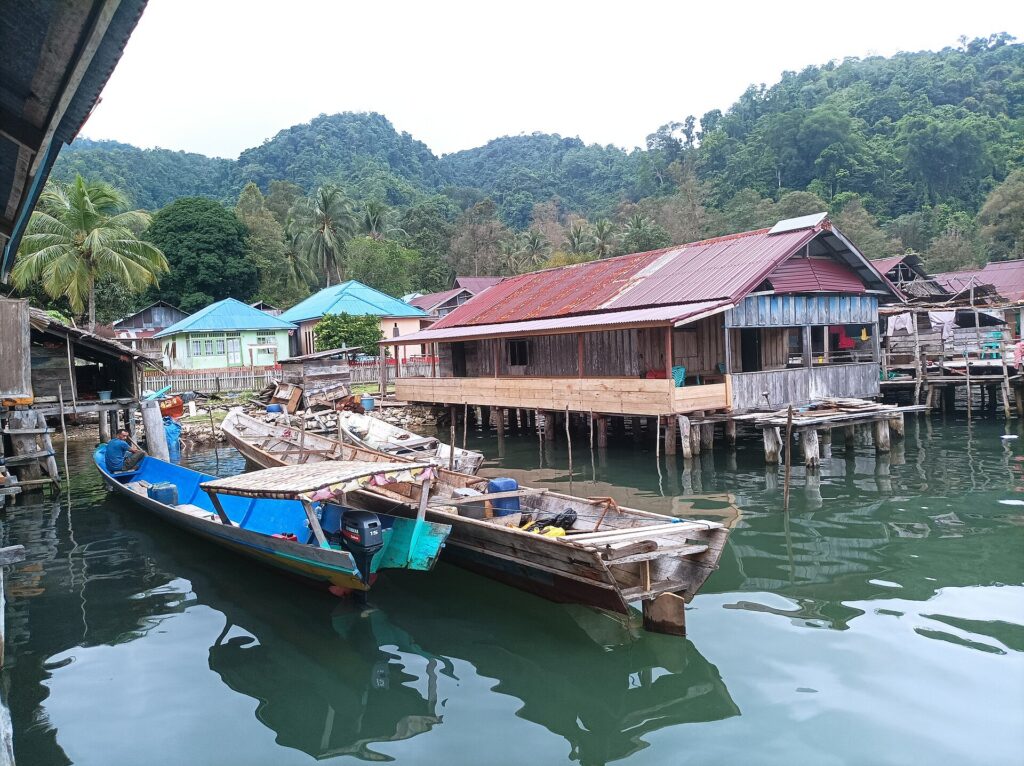 Perahu nelayan dan rumah panggung di pesisir, gambaran program Kampung Nelayan Merah Putih pada berita Lutim
