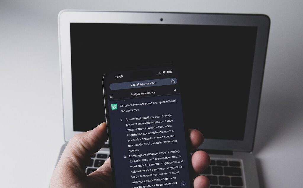 Tangan memegang ponsel pintar yang menampilkan aplikasi ChatGPT di layarnya
