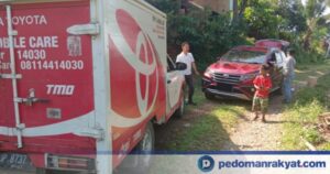 Petugas layanan purna jual mendampingi pelanggan di area servis kendaraan Toyota