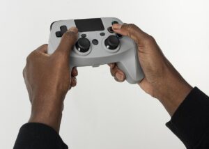 Dua tangan memegang pengendali permainan video, ilustrasi kebiasaan bermain game yang kini menjadi penentu keputusan promosi pengembang indie.