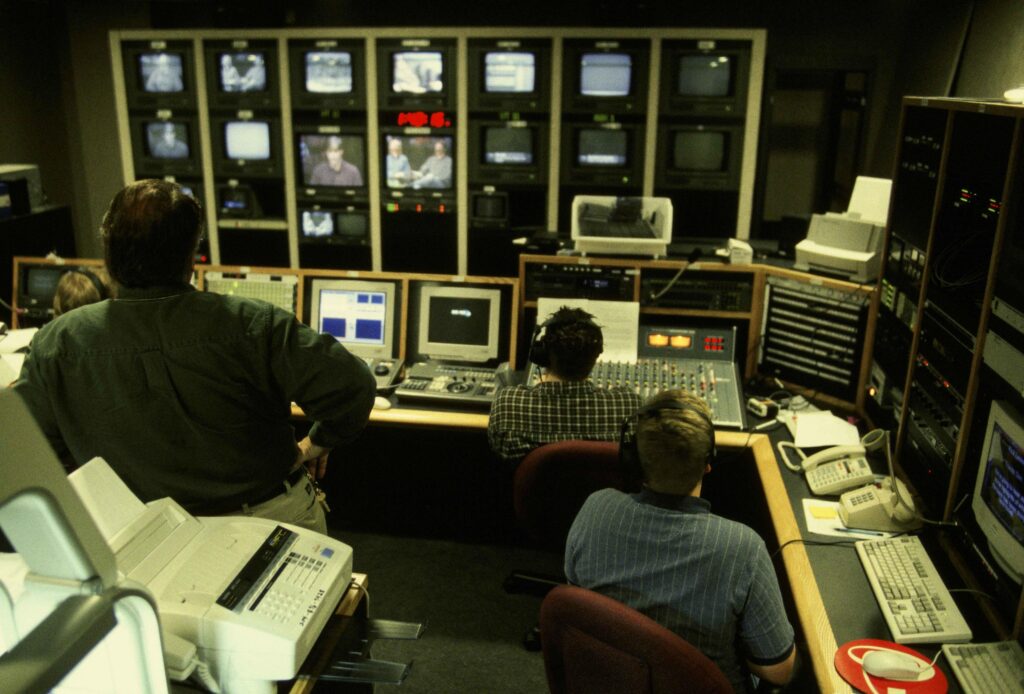 Pekerja produksi video memantau beberapa layar monitor studio
