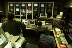 Pekerja produksi video memantau beberapa layar monitor studio