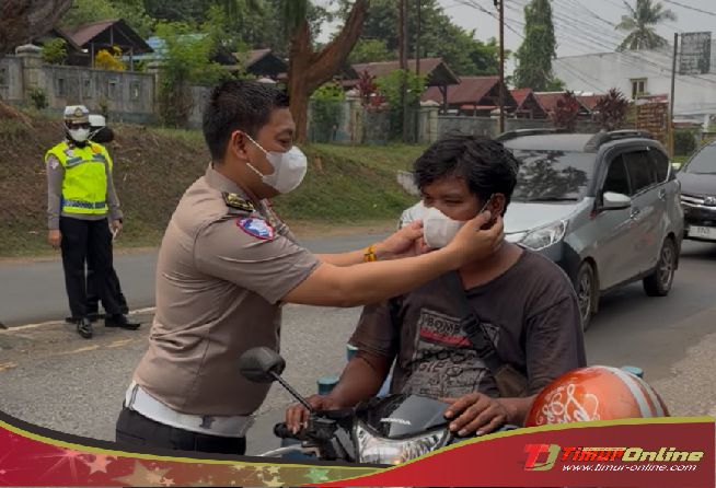Petugas membagikan masker kepada pengendara di Luwu Timur saat kabut asap karhutla