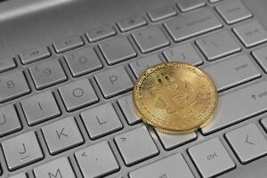 Ilustrasi aset kripto Bitcoin di atas papan tuts komputer