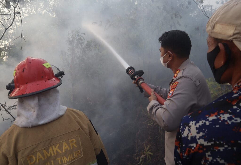 Personel kepolisian dan pemadam kebakaran memadamkan karhutla di perbukitan sekitar Mapolres Luwu Timur yang menjadi sorotan viral luwu timur