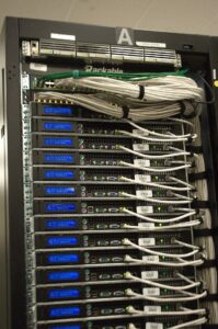 Deretan rak server di pusat data yang menopang layanan kecerdasan buatan